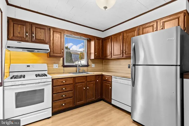 a kitchen with stainless steel appliances granite countertop a stove a sink and a refrigerator