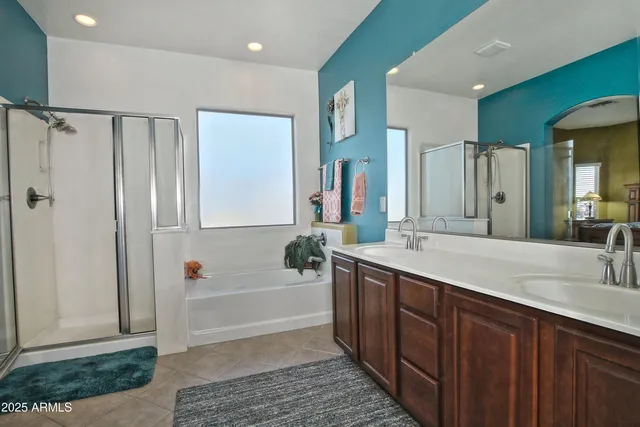 a spacious bathroom with a double vanity sink a mirror and a bathtub