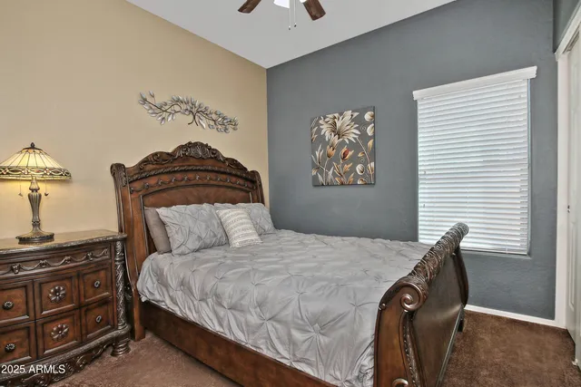 a bedroom with a bed and dresser with mirror