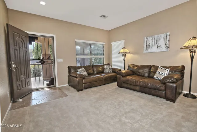 a living room with furniture and a glass door