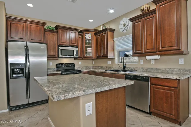 a kitchen with granite countertop a refrigerator and a sink