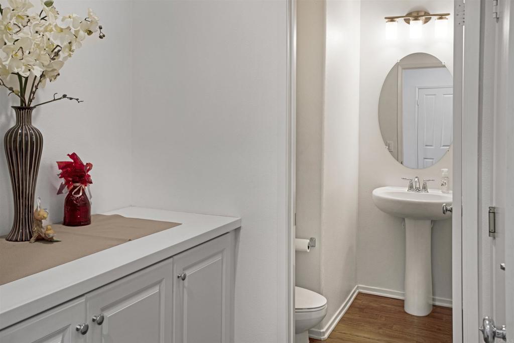 35652 Asturian Way Fallbrook, CA 92028 - Photo 12 of 34 a bathroom with a sink and mirror with wooden floor