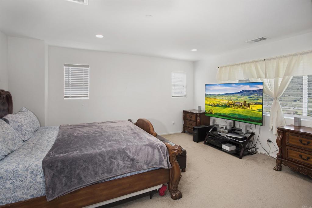 35652 Asturian Way Fallbrook, CA 92028 - Photo 15 of 34 a bedroom with a bed and a flat screen tv