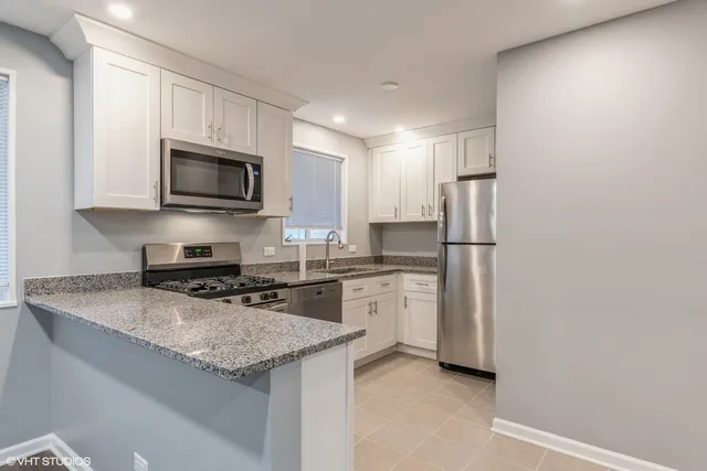 a kitchen with refrigerator a microwave a sink and cabinets