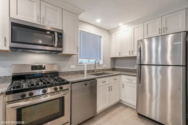 a kitchen with cabinets stainless steel appliances and sink
