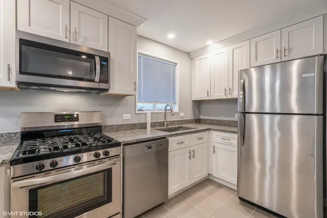 a kitchen with cabinets stainless steel appliances and sink