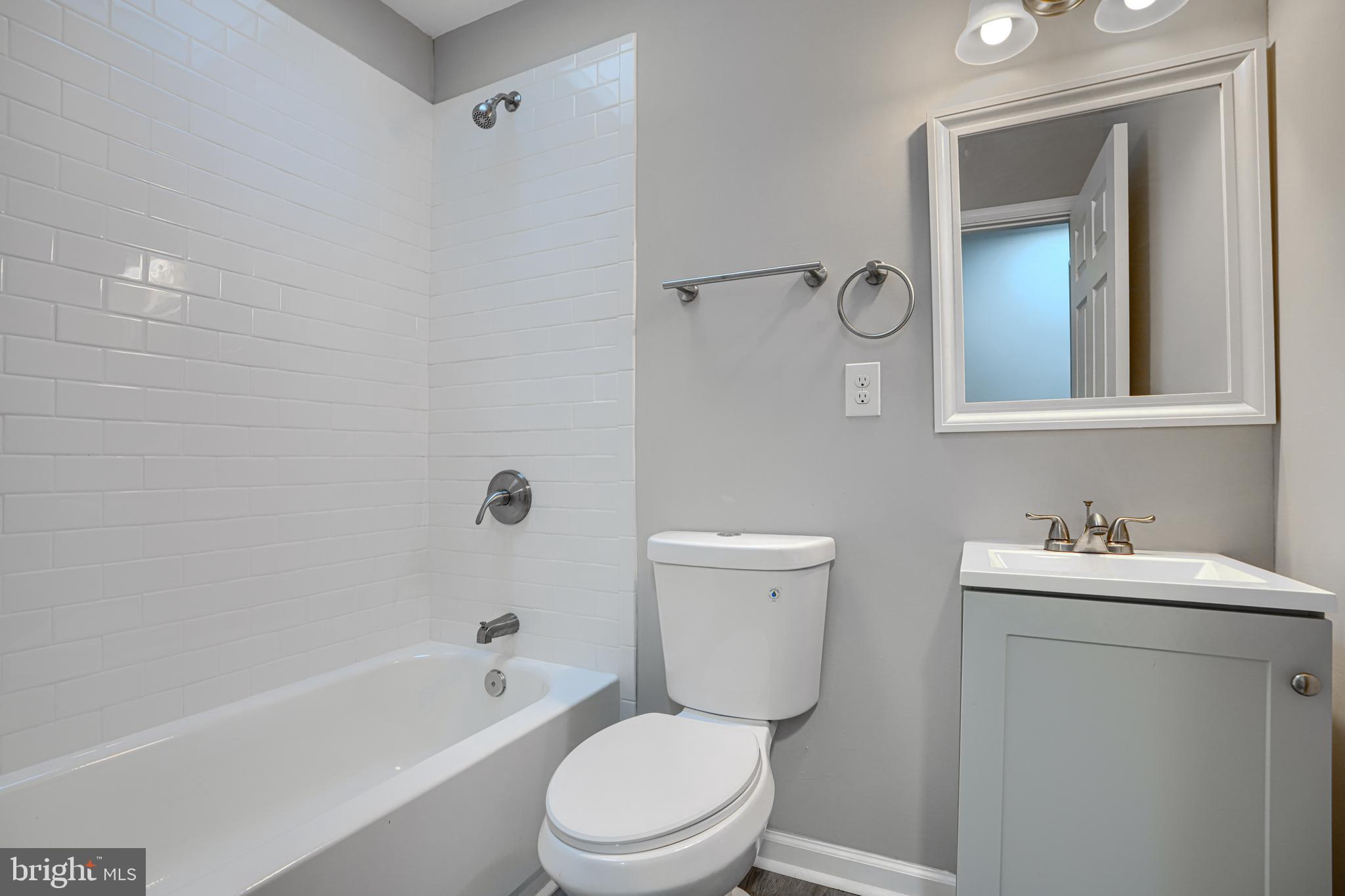 717 North Streeper Street Baltimore, MD 21205 - Photo 19 of 29 a bathroom with a toilet a sink a mirror a bathtub and vanity