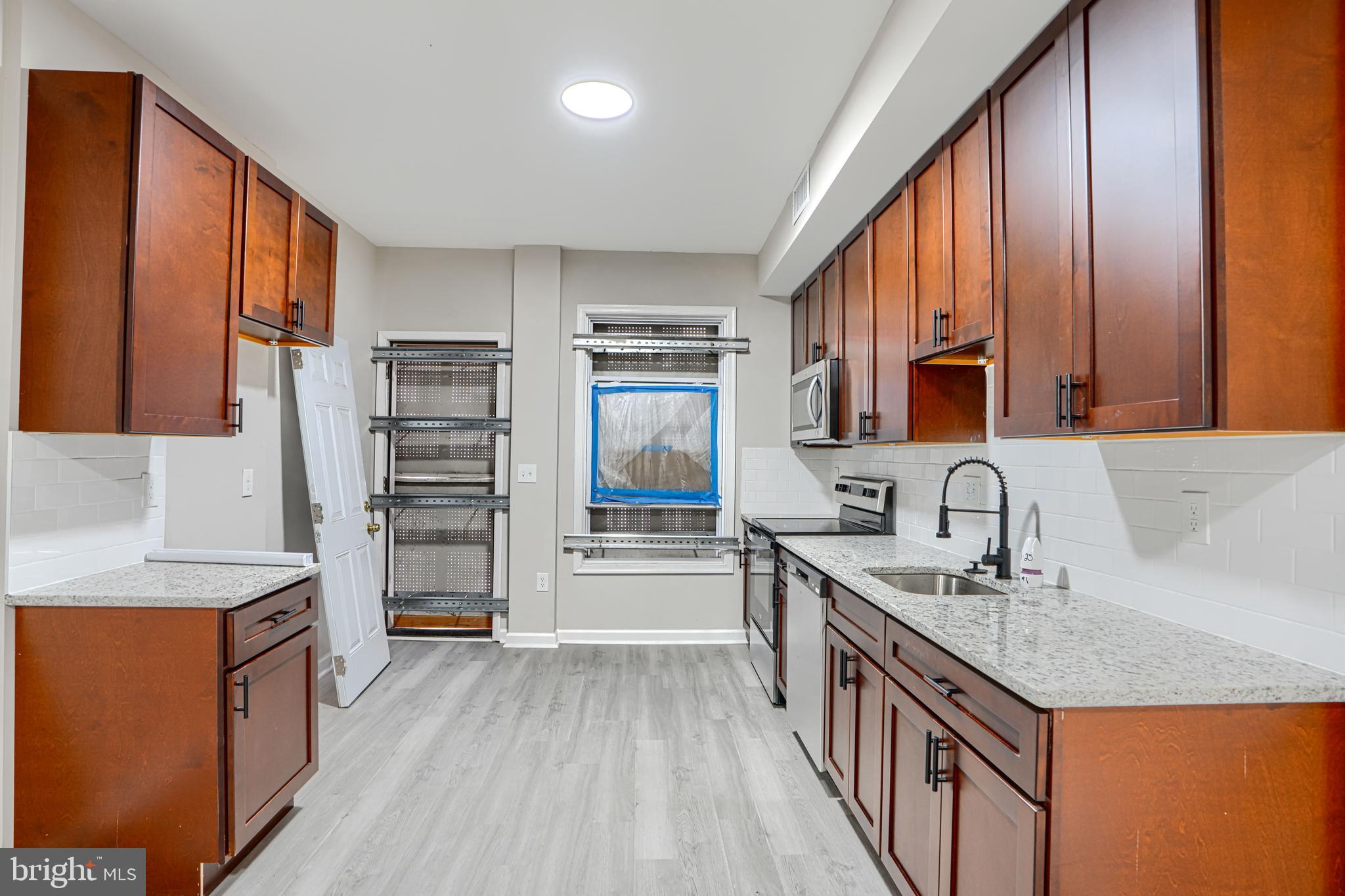 717 North Streeper Street Baltimore, MD 21205 - Photo 7 of 29 a kitchen with granite countertop a sink stove and cabinets