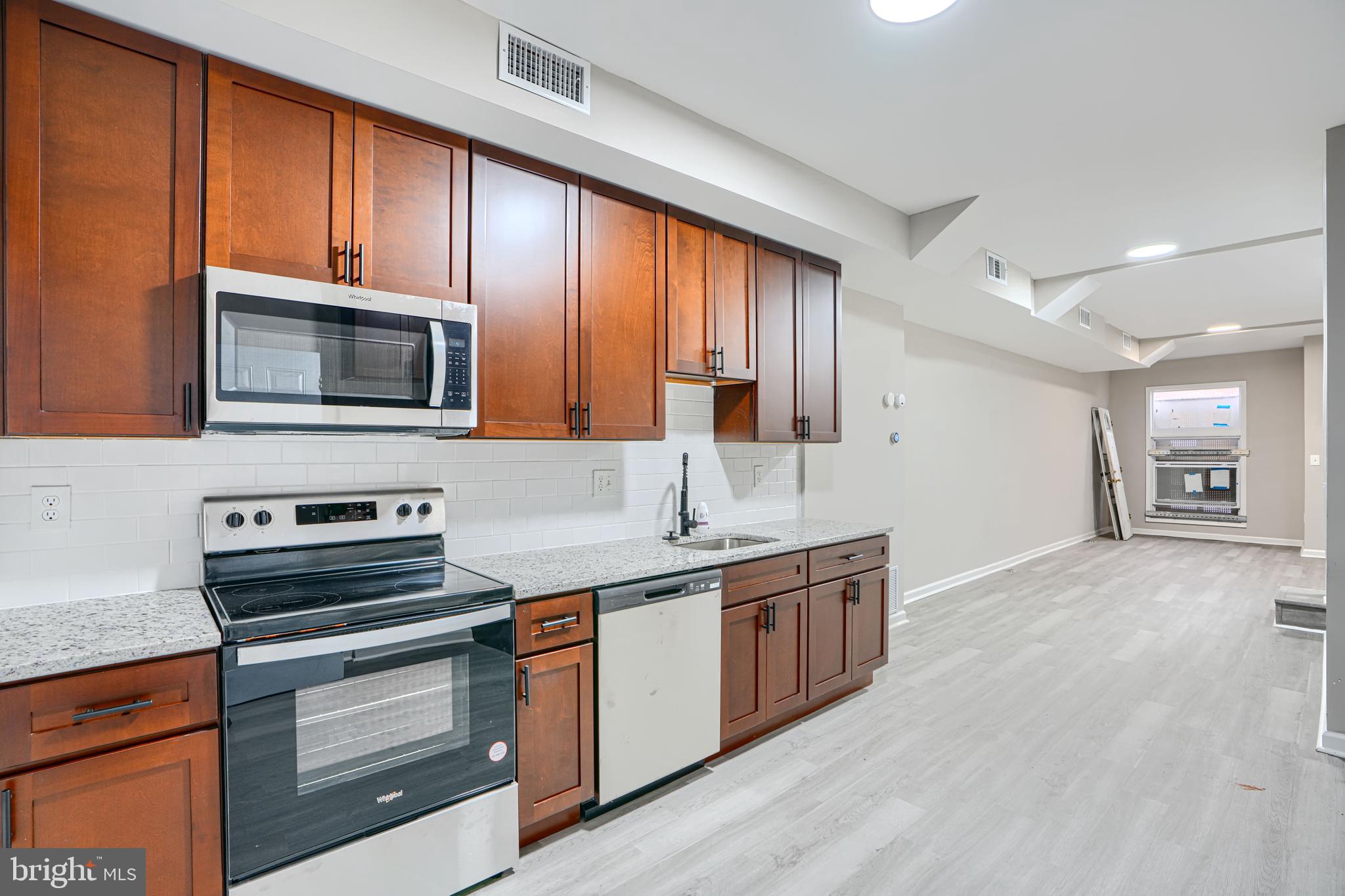 717 North Streeper Street Baltimore, MD 21205 - Photo 9 of 29 a kitchen with stainless steel appliances a stove sink microwave and cabinets