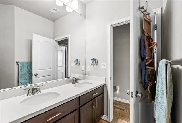 a bathroom with a double vanity sink a mirror and a shower