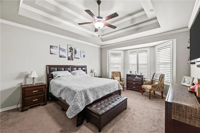 a spacious bedroom with a bed a couch and a large window