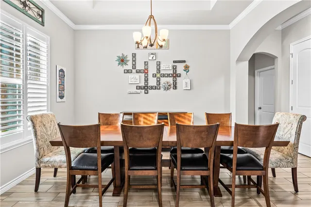 a dining room with furniture a chandelier and wooden floor
