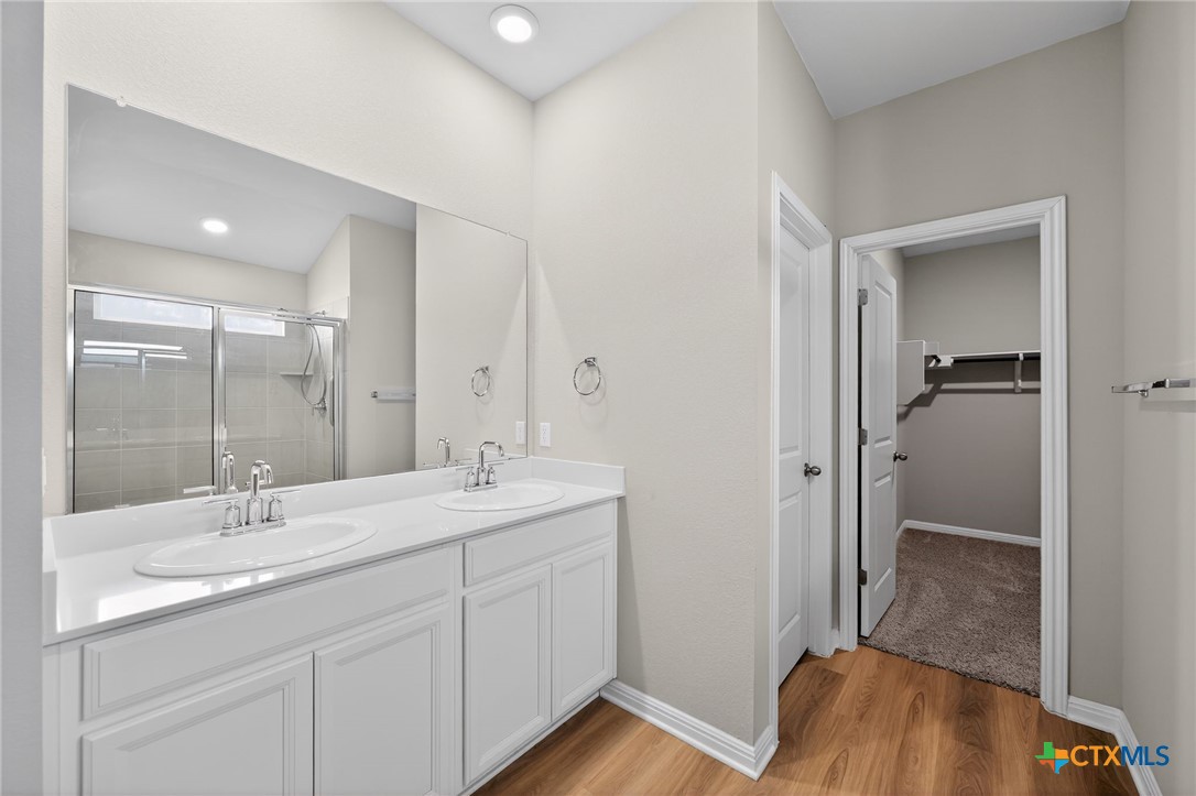 900 Main Street Hutto, TX 78634 - Photo 15 of 23 a en suite bathroom with a granite countertop sink mirror and toilet