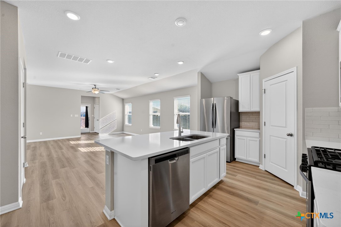 900 Main Street Hutto, TX 78634 - Photo 4 of 23 a kitchen with stainless steel appliances granite countertop a sink stove and refrigerator