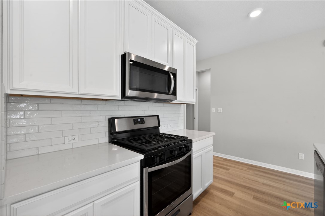 900 Main Street Hutto, TX 78634 - Photo 5 of 23 a kitchen with stainless steel appliances a stove microwave and sink