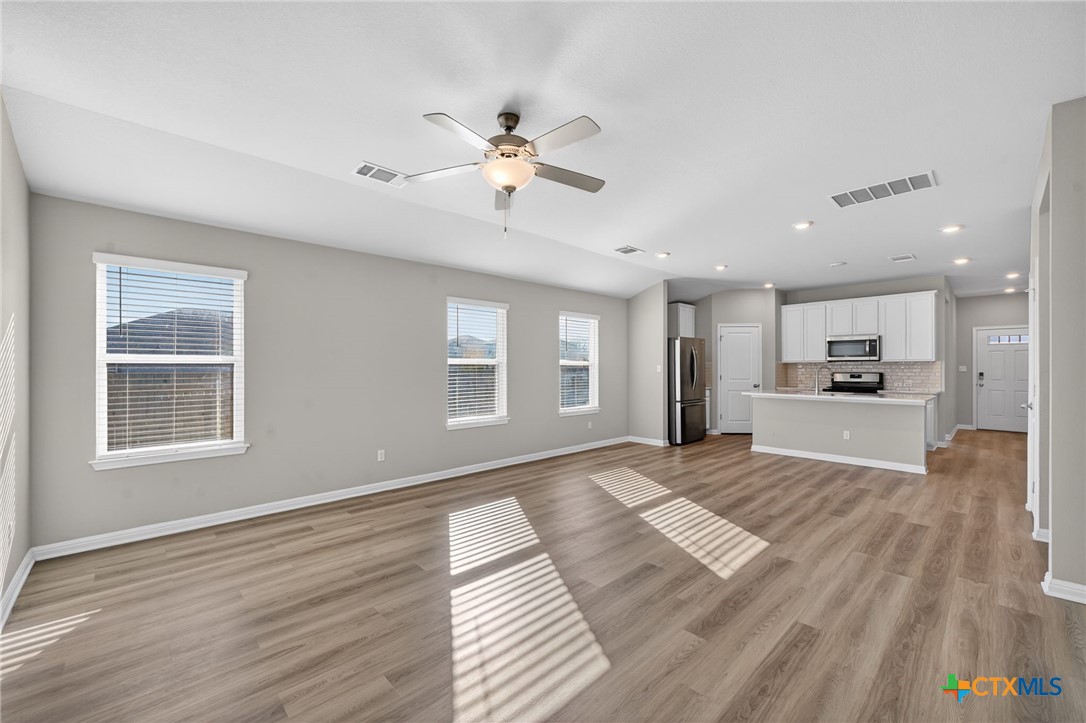900 Main Street Hutto, TX 78634 - Photo 7 of 23 a view of an empty room with a window and wooden floor