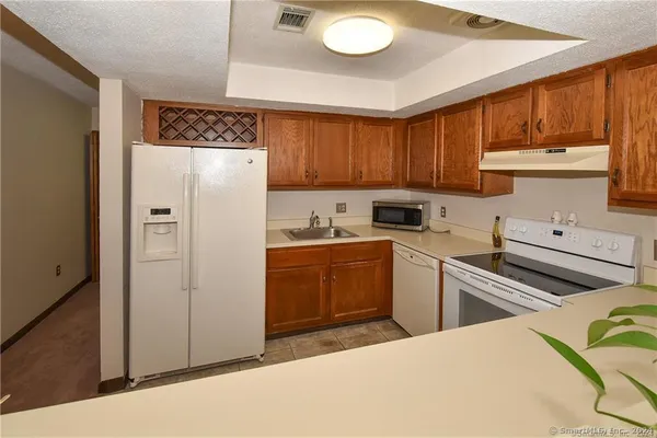 a kitchen with a refrigerator sink and cabinets