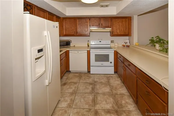 a kitchen with white cabinets and white appliances