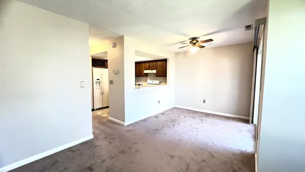 an empty room with windows and fan