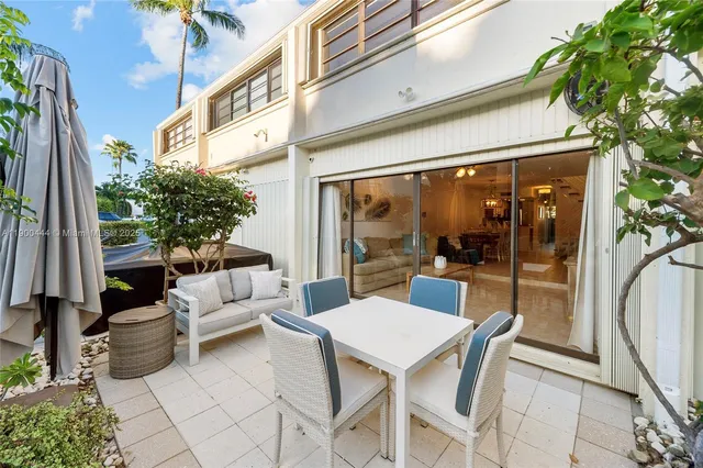 a view of a patio with a dining table and chairs with wooden floor