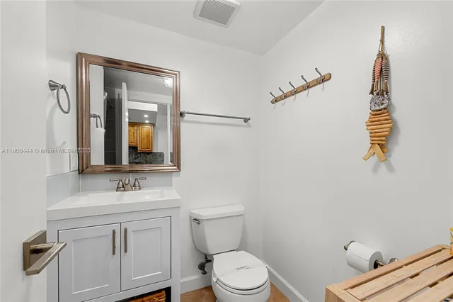 a bathroom with a toilet sink vanity and mirror