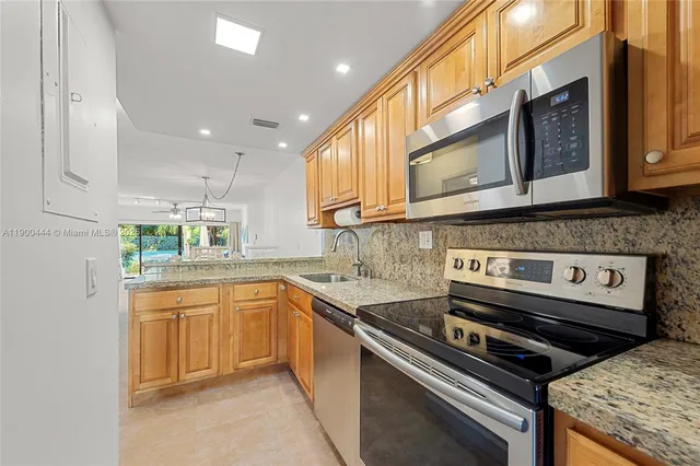 a kitchen with stainless steel appliances granite countertop a stove and a sink