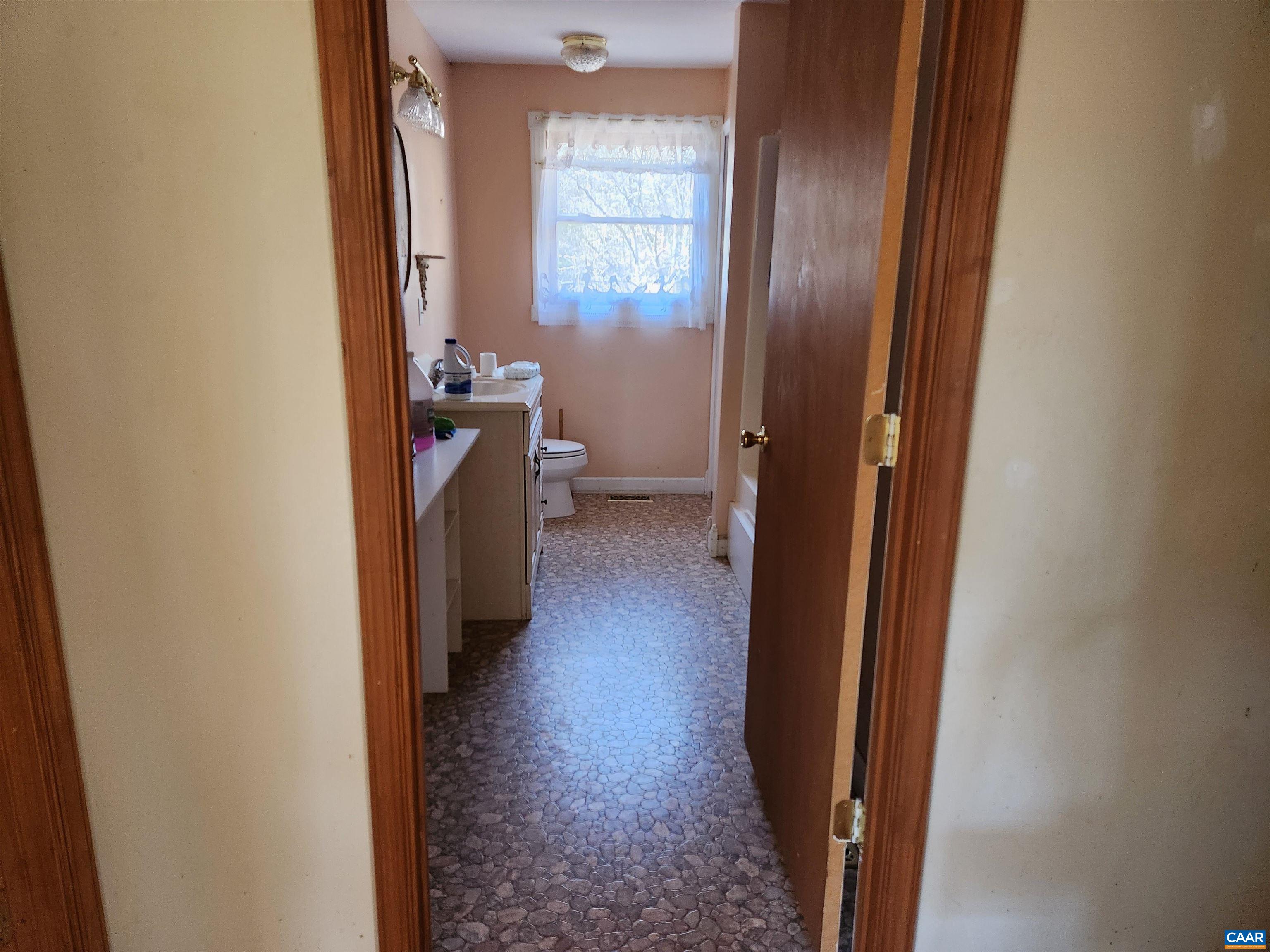 481 Rhodes School Lane Palmyra, VA 22963 - Photo 24 of 34 a view of a hallway with wooden floor and a bathroom