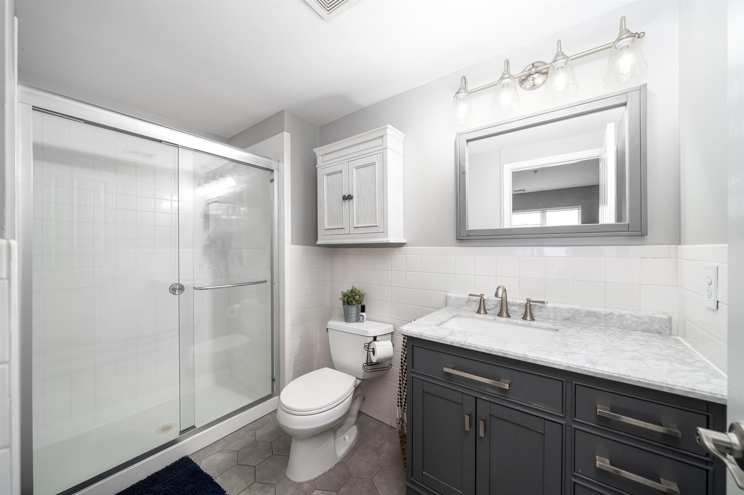536 Grand Street, Unit 403 Hoboken, NJ 07030 - Photo 8 of 15 a bathroom with a sink a toilet and vanity