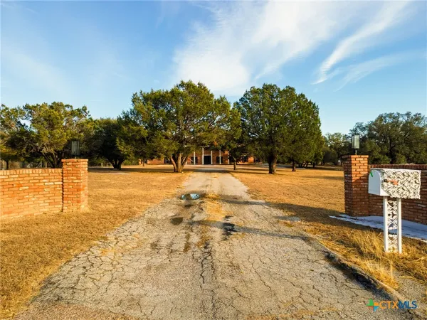 a front view of a house with a large tree