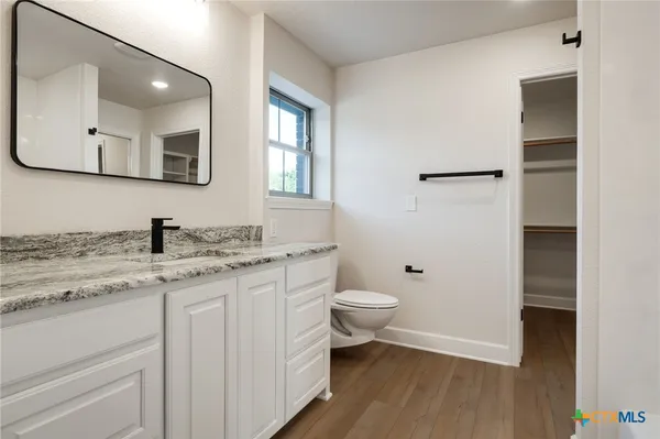 a bathroom with a double vanity sink a mirror and a bathtub
