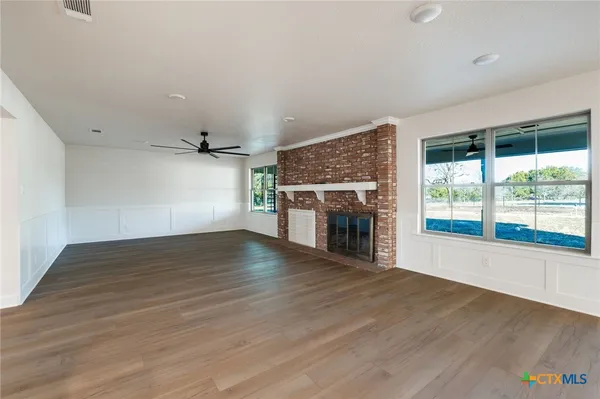 a kitchen with a sink cabinets stainless steel appliances and wooden floor