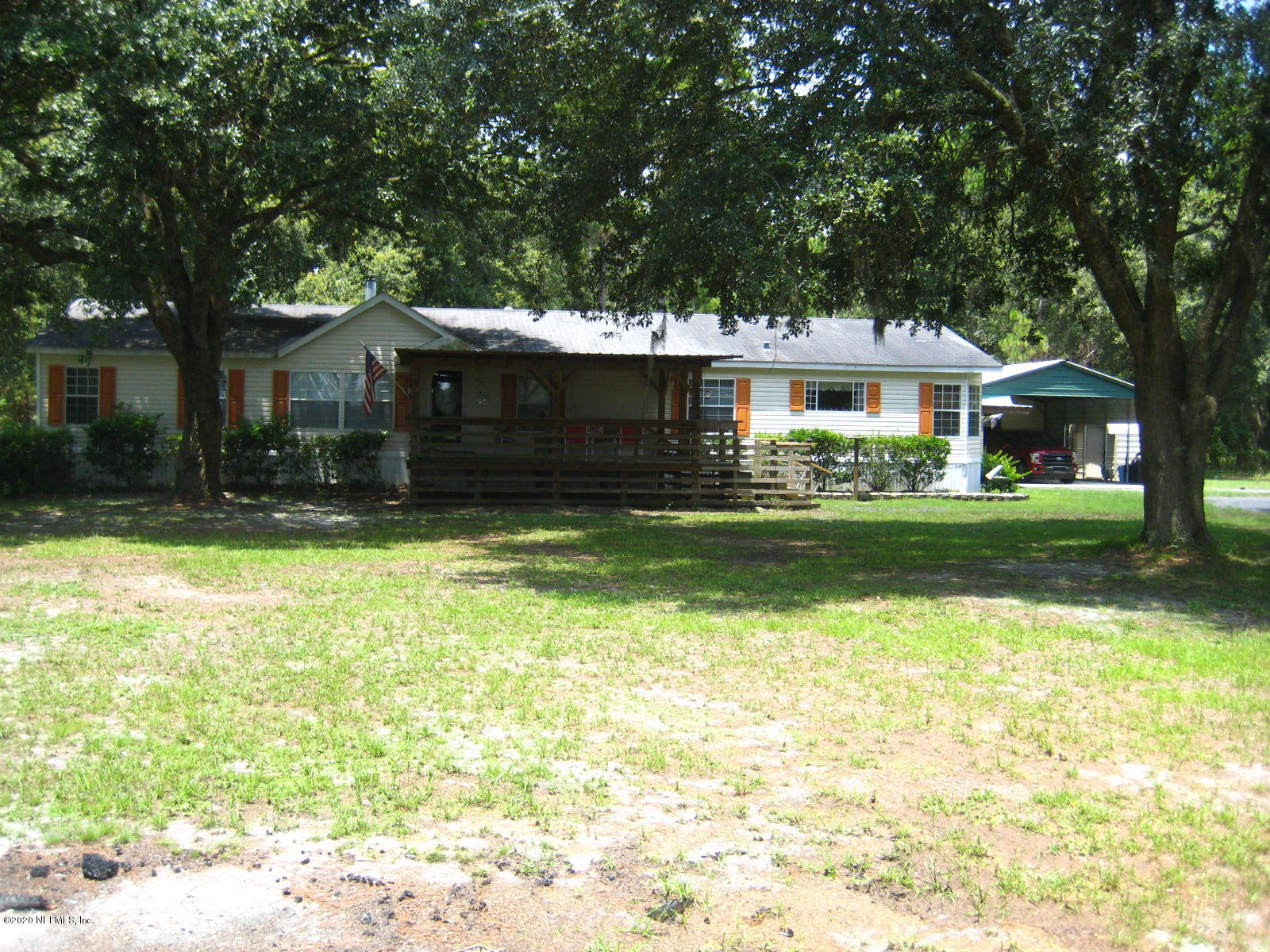 a front view of house with yard and trees in the background