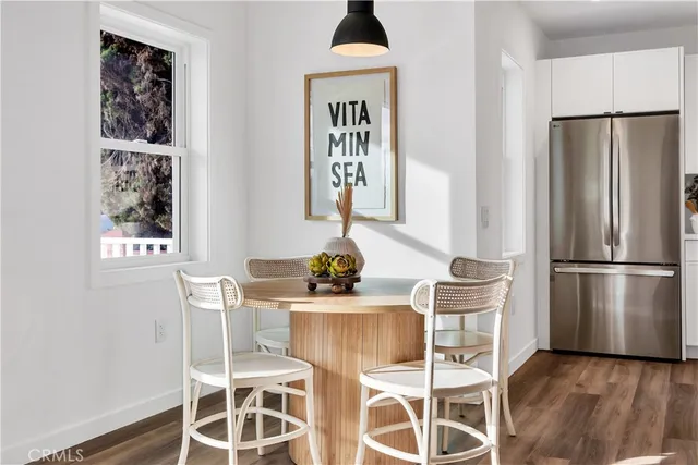 a kitchen with stainless steel appliances a dining table chairs and a refrigerator