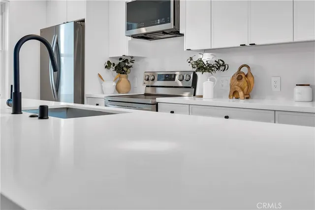 a kitchen with stainless steel appliances granite countertop a refrigerator and a stove top oven