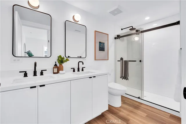 a bathroom with a double vanity sink mirror and toilet