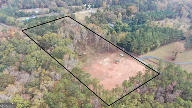 an aerial view of a house with a yard and mountain view in back