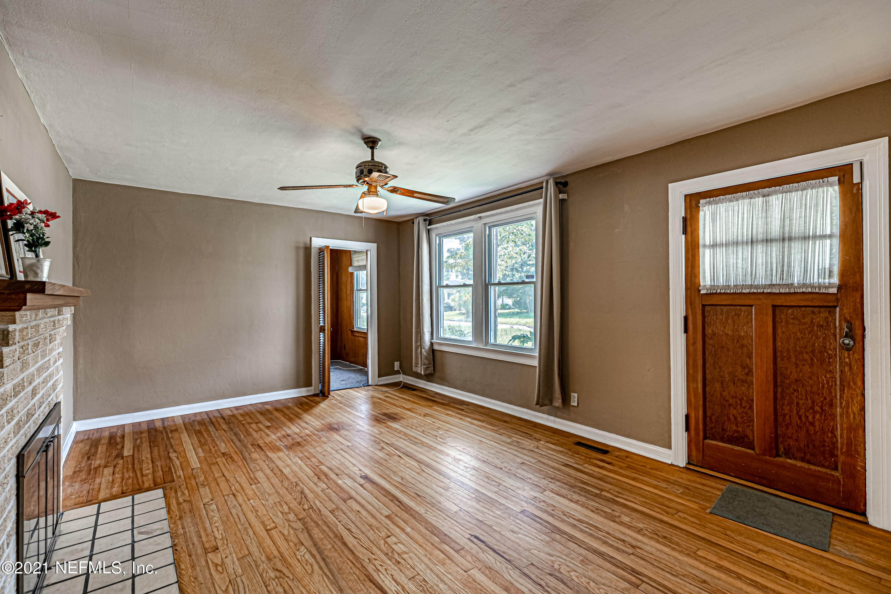 4627 Birkenhead Road Jacksonville, FL 32210 - Photo 7 of 30 a view of an empty room with wooden floor and a window
