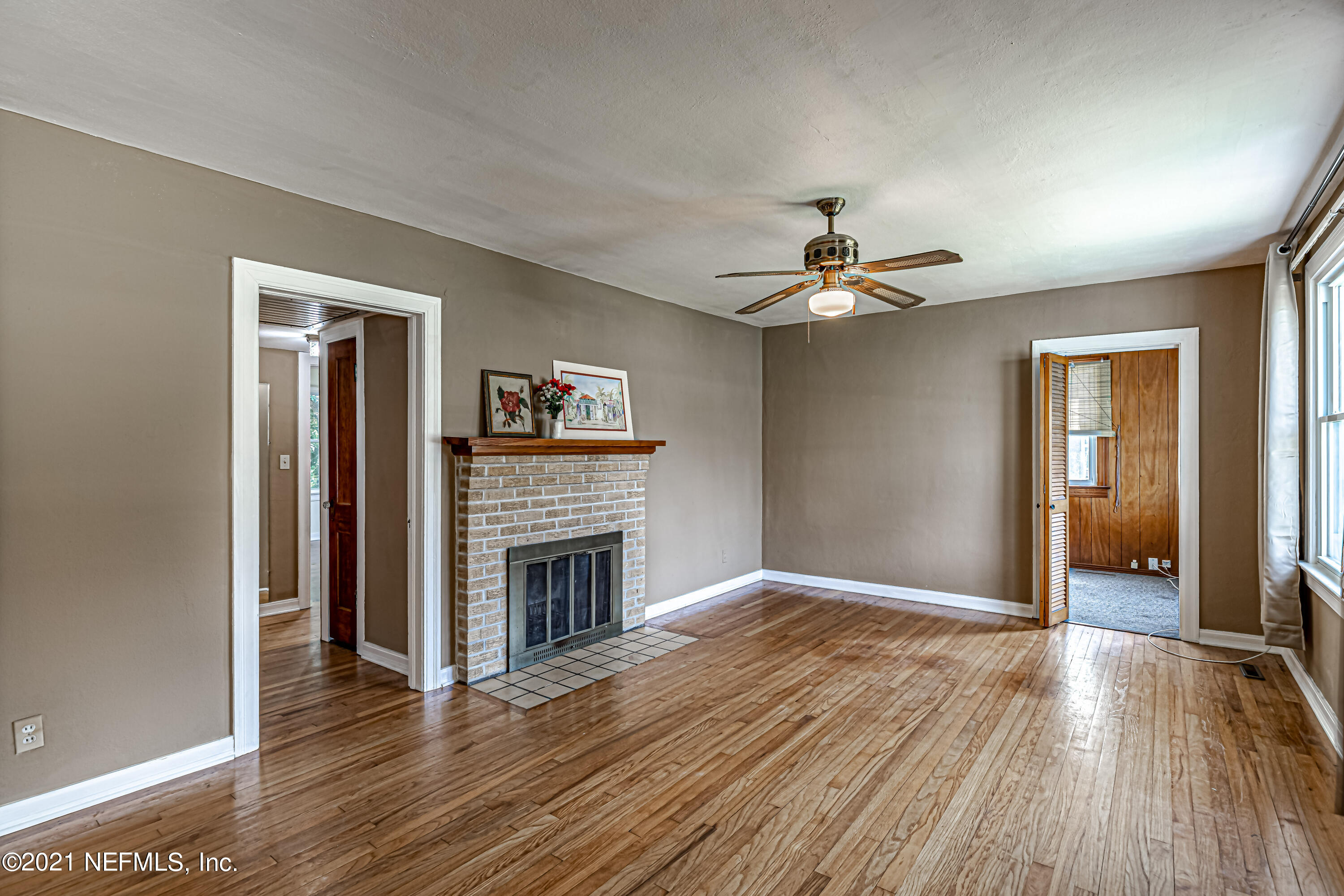 4627 Birkenhead Road Jacksonville, FL 32210 - Photo 8 of 30 a view of an empty room with wooden floor and a fireplace