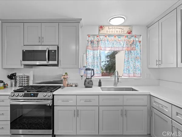 a kitchen with white cabinets and appliances