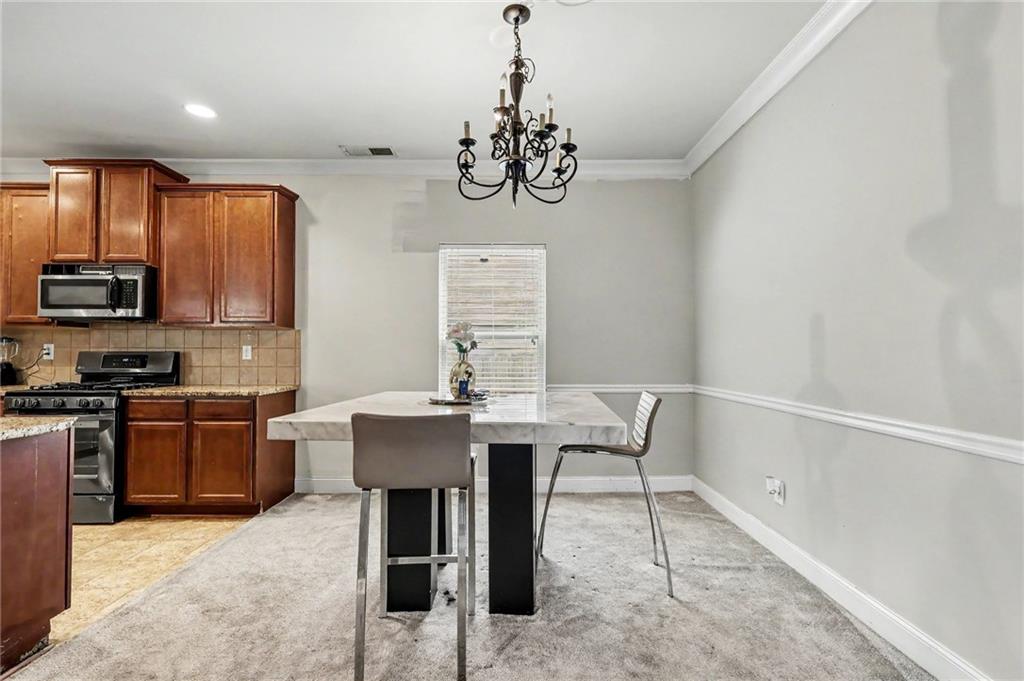 2780 Lakeview Walk Decatur, GA 30035 - Photo 14 of 37 a kitchen with stainless steel appliances granite countertop a sink dishwasher a stove a refrigerator with a dining table and chairs