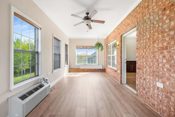 a view of a hallway with wooden floor and a large window