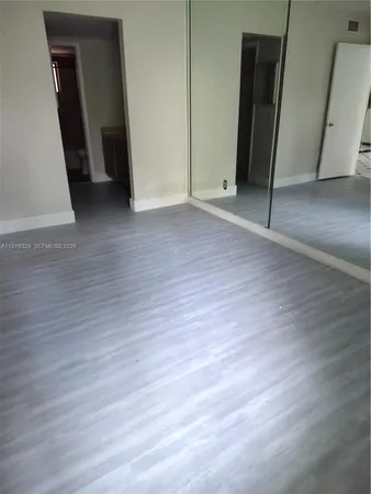 an empty room with wooden floor and closet