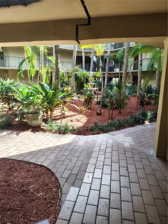 a view of a porch with chairs and potted plants