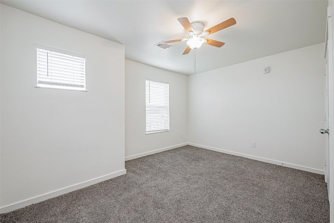 21155 Gosling Road, Unit 15 AB Spring, TX 77388 - Photo 16 of 30 Spacious bedroom with neutral carpeting, ceiling fan, and an en-suite bathroom featuring modern fixtures.