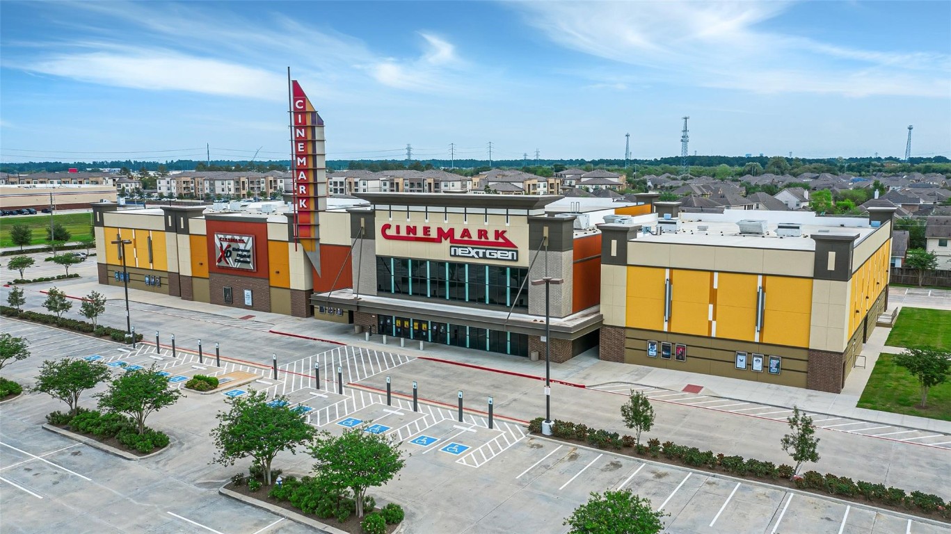 21155 Gosling Road, Unit 15 AB Spring, TX 77388 - Photo 28 of 30 This photo shows a modern cinema complex with ample parking, situated in a spacious area with nearby residential buildings. Ideal for entertainment, it's conveniently located near housing, offering easy access to leisure activities.