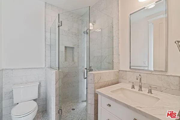 a bathroom with a granite countertop sink toilet and shower