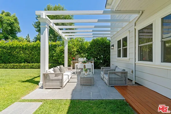 a view of a patio with couches chairs potted plants and a big yard