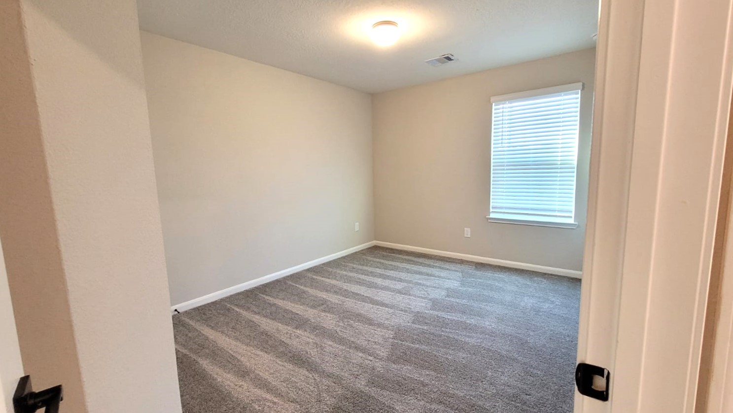 5704 Bluebonnet Lane Rosenberg, TX 77469 - Photo 27 of 34 an empty room with wooden floor and windows