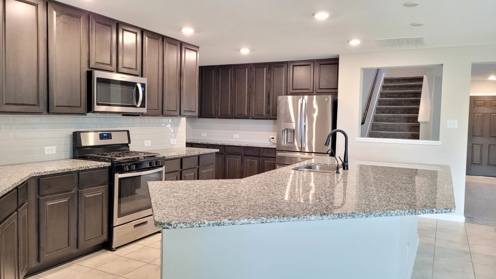 5704 Bluebonnet Lane Rosenberg, TX 77469 - Photo 5 of 34 a kitchen with granite countertop wooden cabinets stainless steel appliances and a sink