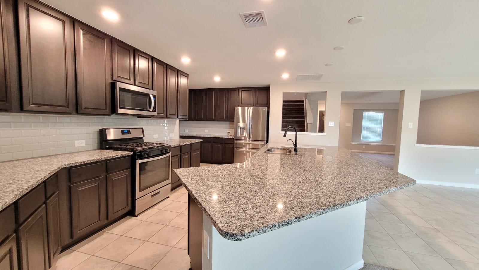 5704 Bluebonnet Lane Rosenberg, TX 77469 - Photo 6 of 34 a kitchen with stainless steel appliances granite countertop a sink dishwasher a stove and a refrigerator with wooden floor